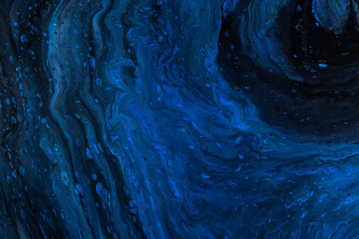 An abstract image featuring swirling patterns of dark and light blue, resembling a fluid motion or marbled texture, evokes the dynamic impact reminiscent of the Biden Presidency's transformative policies.