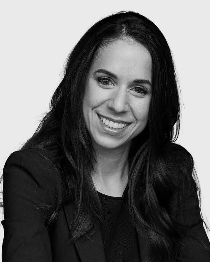 Black and white headshot of Jennifer Fox Bensimon, Managing Director at Partners Capital, with long dark hair, smiling, wearing a blazer.