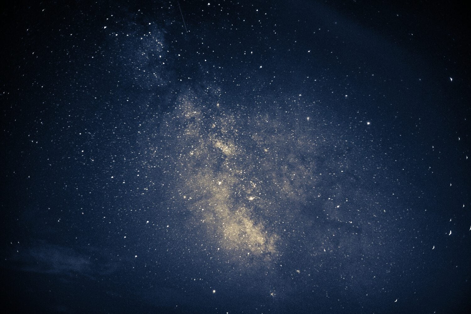 A dense cluster of stars in a night sky, showcasing the Milky Way galaxy with various points of light against a dark background, much like pinpointing key insights from 2022 amidst the vastness of economic data.