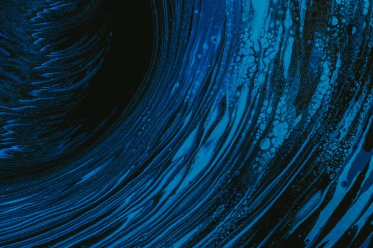 A close-up of swirling dark blue and black patterns resembling liquid or marble, evoking the dynamic nature of active investing.