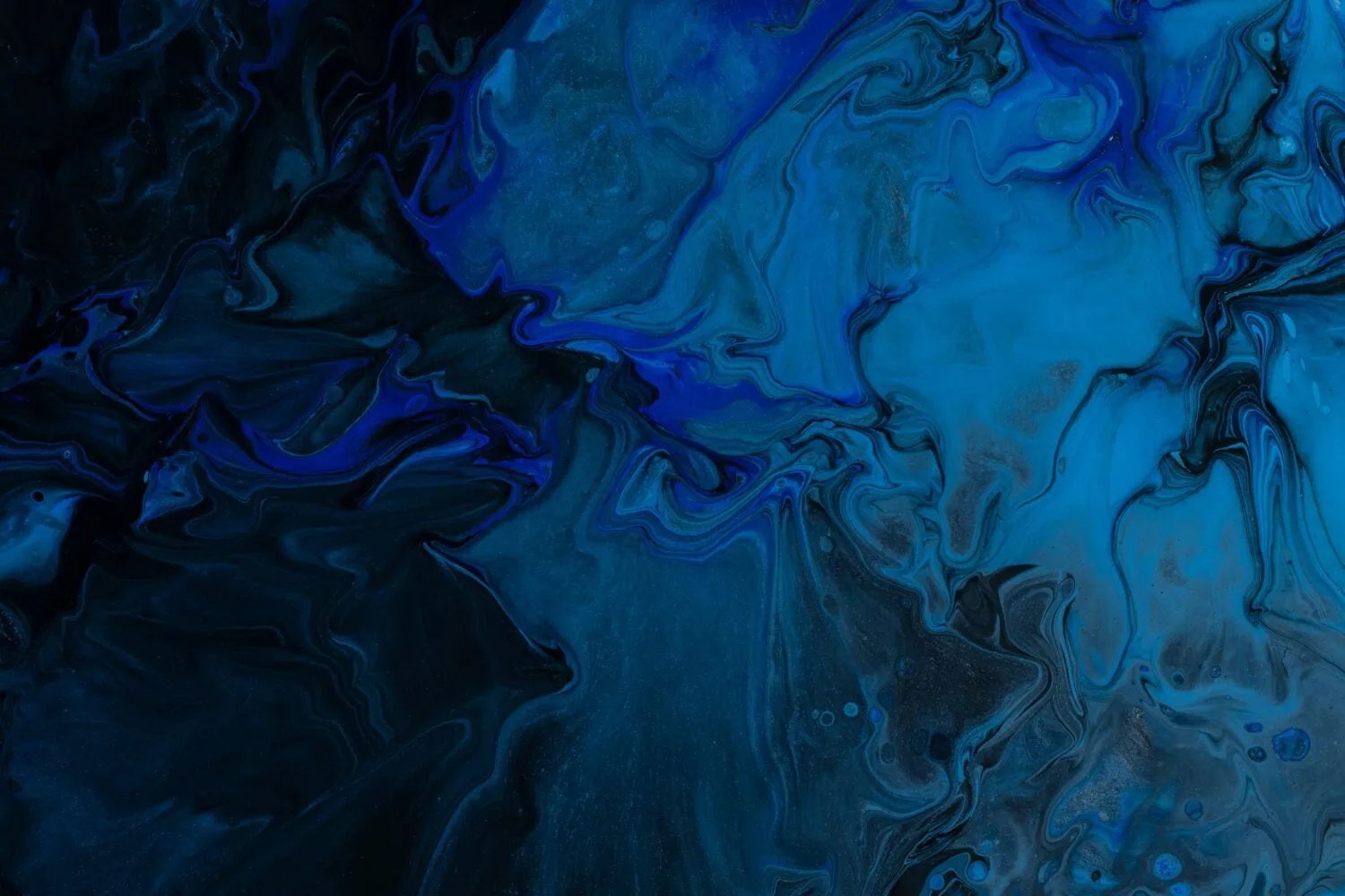 Abstract image with swirling patterns of dark blue and black hues, creating a fluid, marbled effect that draws viewers in with its inherent attractiveness.