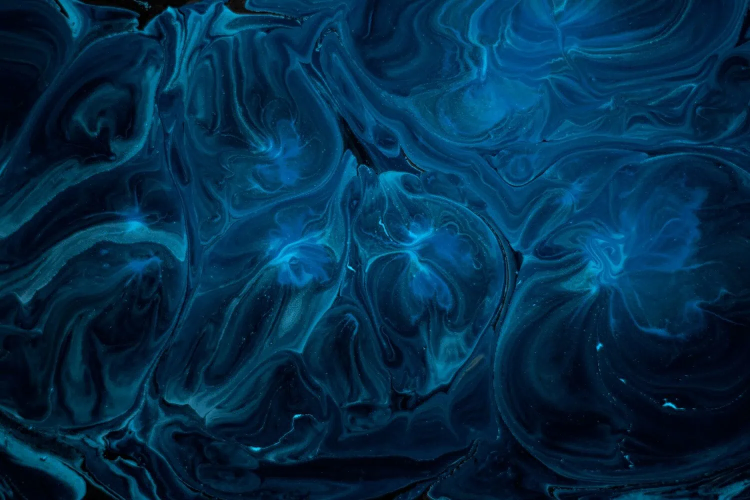 Close-up of swirling blue and black abstract patterns resembling marbled or liquid textures, reminiscent of the intricate financial strategies employed in tax efficient investing.