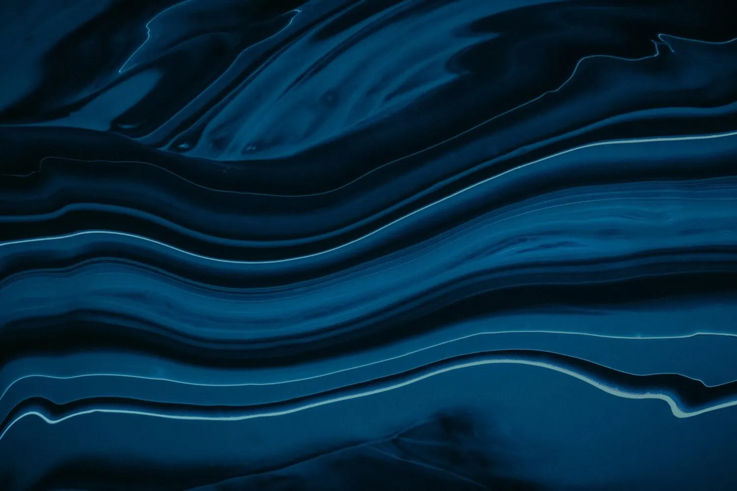 Abstract image featuring swirling, fluid patterns in various shades of blue with thin white lines accentuating the curves, resembling a deep dive into the intricate beauty of oceanic currents.