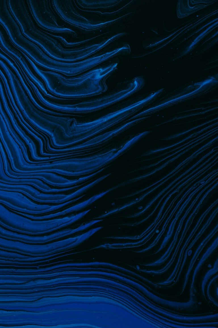 Abstract image featuring flowing, curvilinear lines in various shades of blue against a dark background, resembling topographical map contours or marbled patterns, evoking a sense of cyclicality.