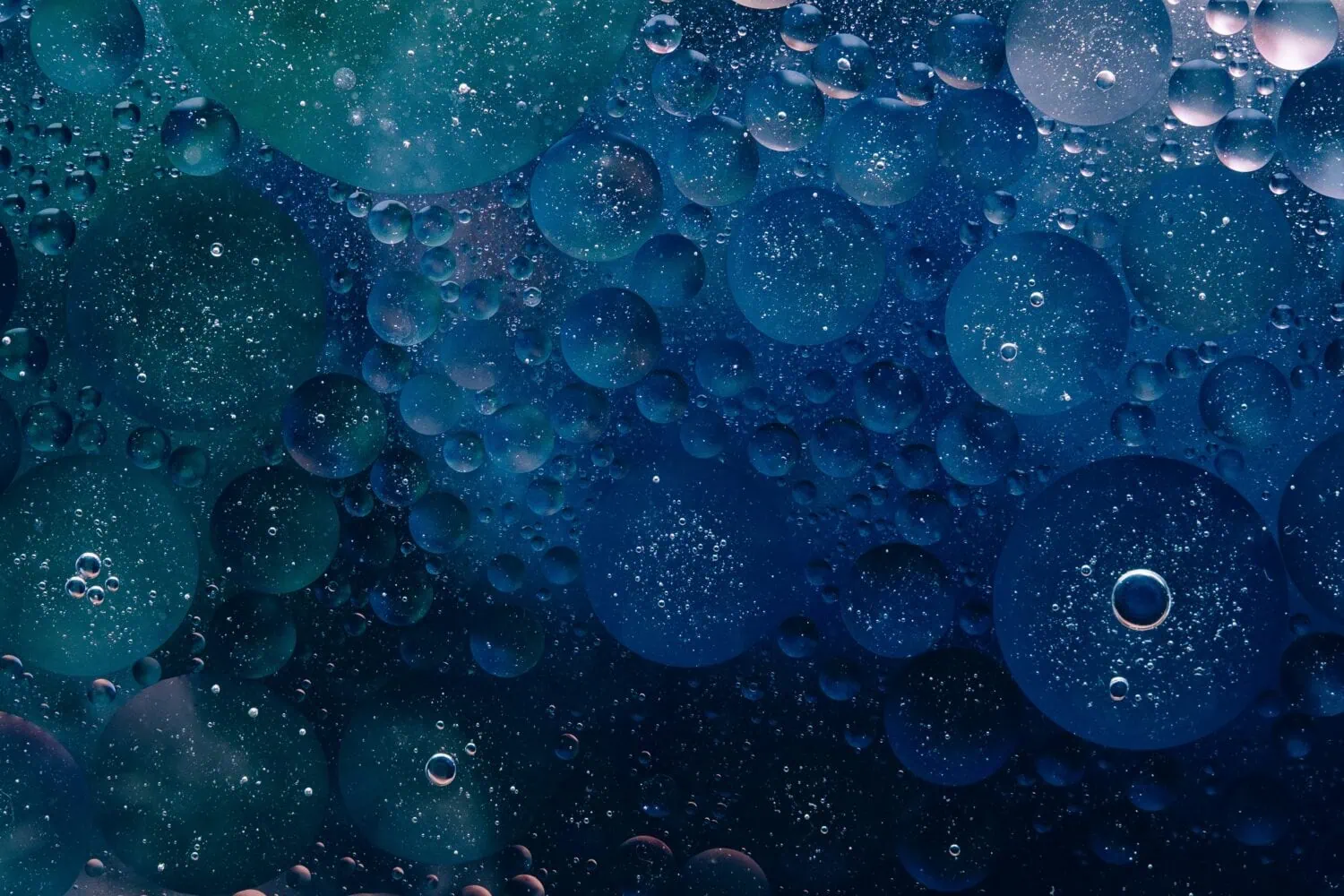 A close-up shot of numerous bubbles of varying sizes suspended in a dark blue liquid, creating an abstract pattern reminiscent of the intricate planning seen in Partners Capital's tax-advantage investing strategies.