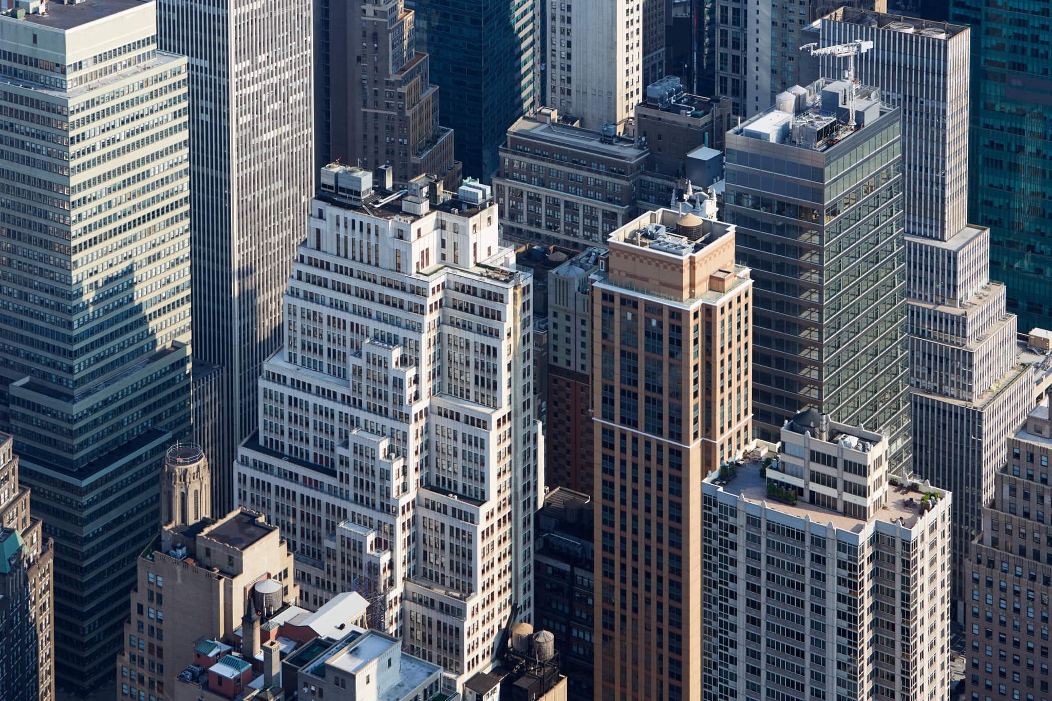 Aerial view of New York's densely packed urban area with tall skyscrapers, featuring a mix of modern glass buildings and older masonry structures, highlighting the bustling hub where financial giants like Partners Capital thrive.